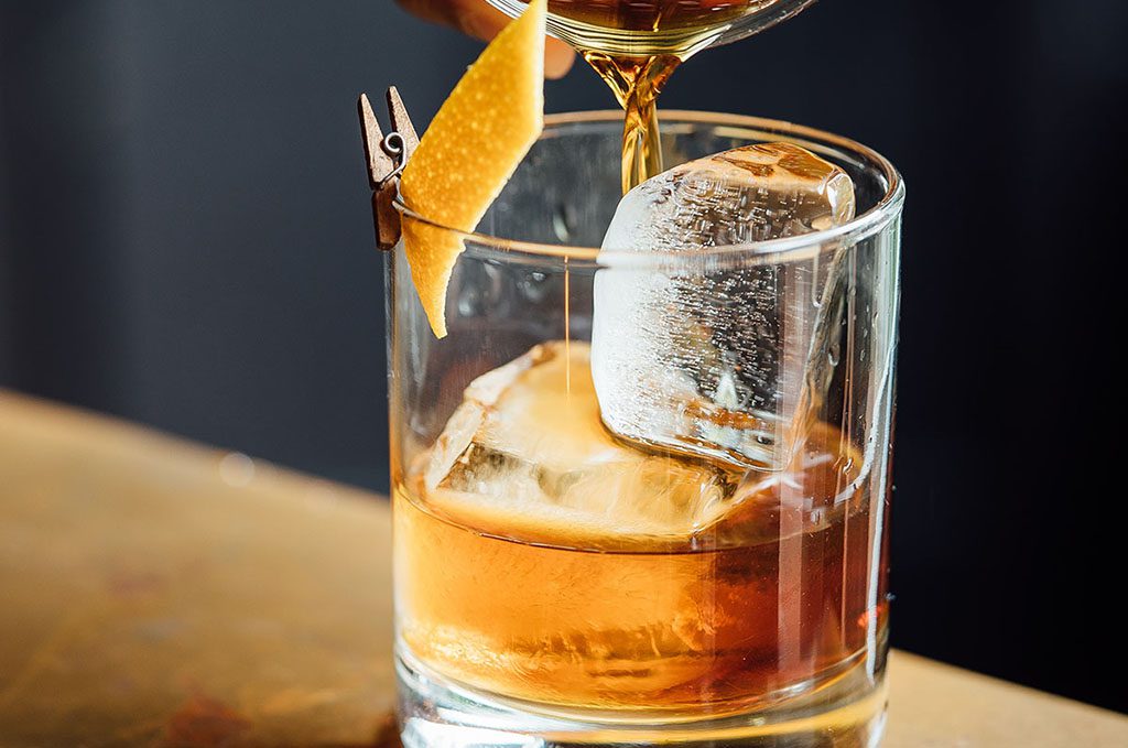 B52 cocktail being poured into a glass with ice