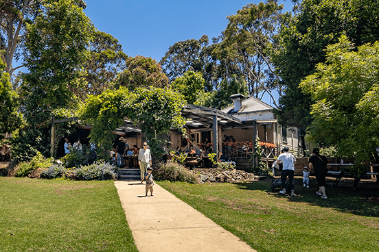 A Cottage Cafe with people sitting at tables, walking through the grounds